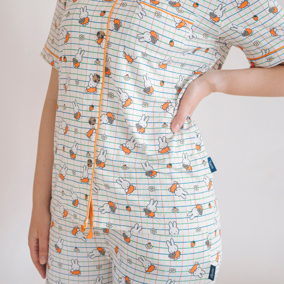Vrouw die de Ladies nijntje Checkered Bloom-pyjamaset van bamboe draagt