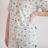 Vrouw die de Ladies nijntje Checkered Bloom-pyjamaset van bamboe draagt