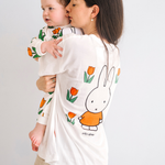 Vrouw die het nijntje witte borstvoeding-T-shirt draagt met een geborduurde tulp en borstvoedingsritsen